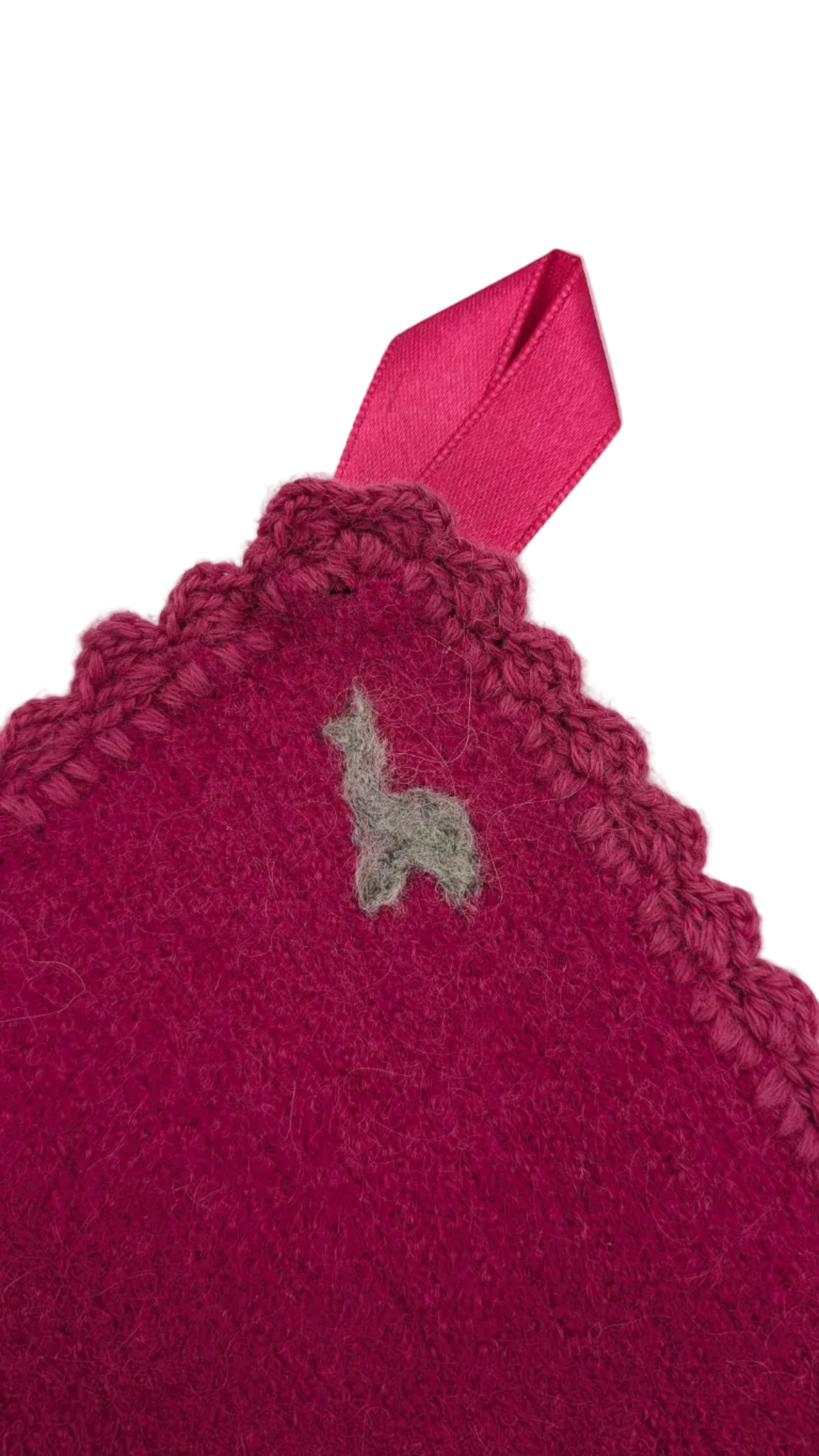 Pink knitted blanket with a small gray alpaca design felted on