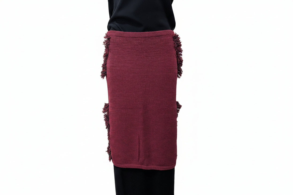 Maroon skirt with fringe details worn by a person against a plain background