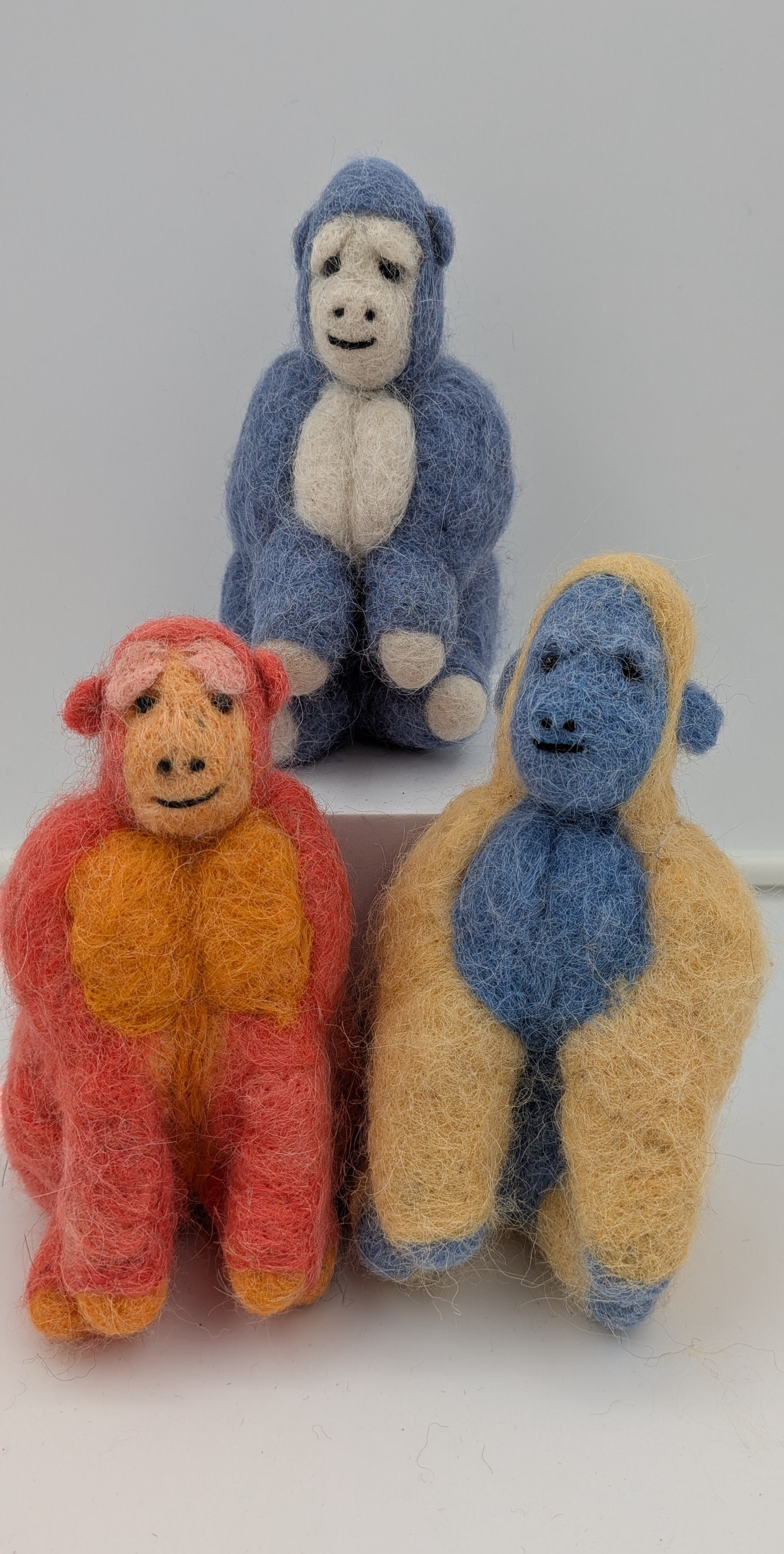 Three colorful monkey figurines on a white background