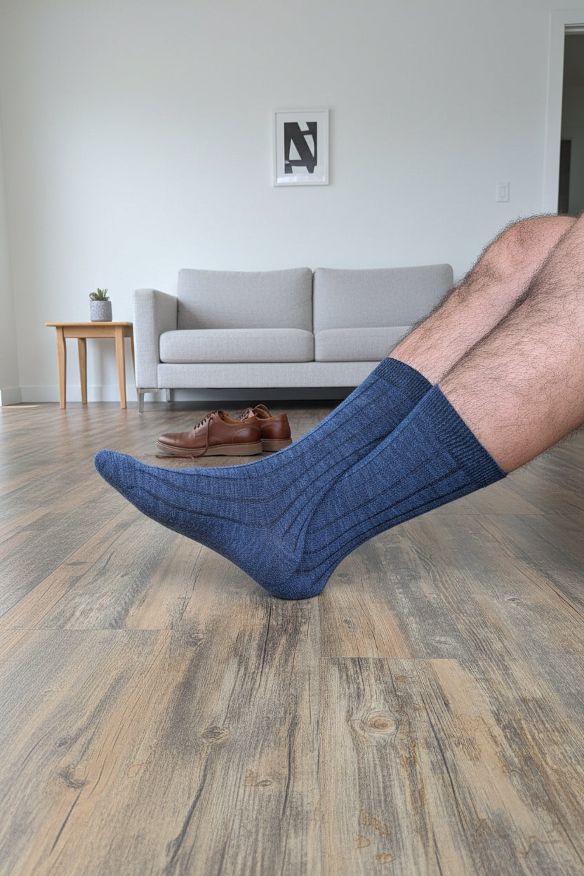 Person wearing blue socks on a wooden floor with storage bins in the background
