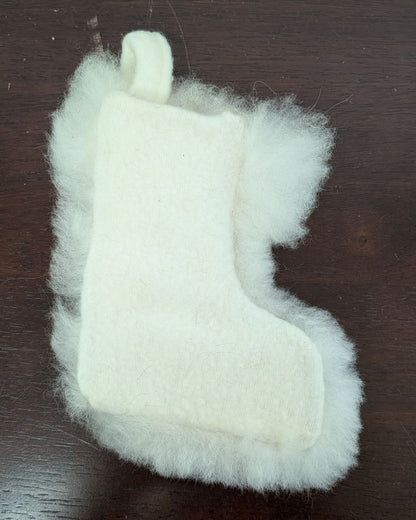White fuzzy stocking toy on a dark wooden surface