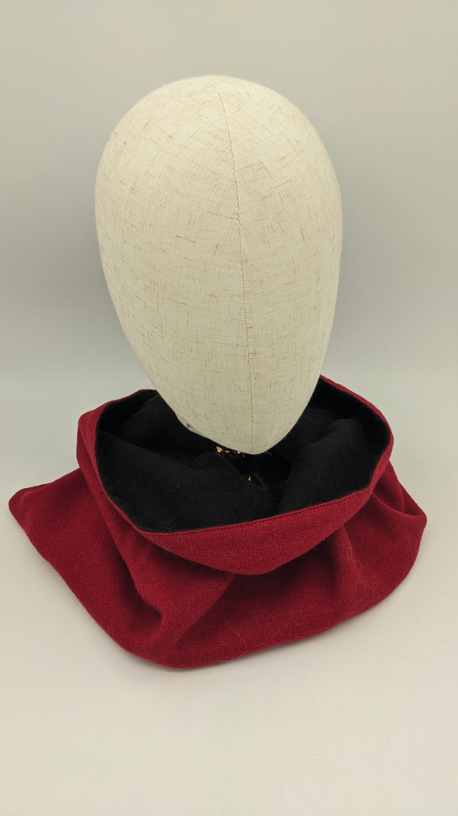Red scarf on a mannequin head against a plain background