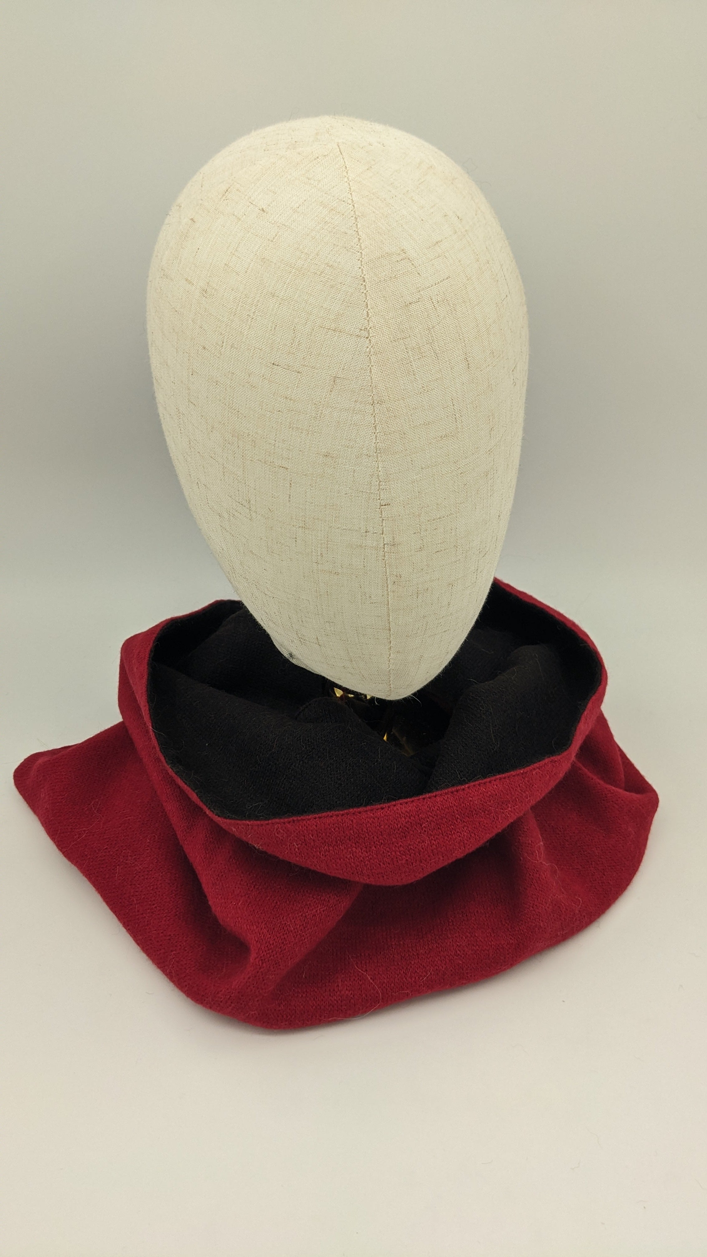 Red scarf on a mannequin head against a plain background
