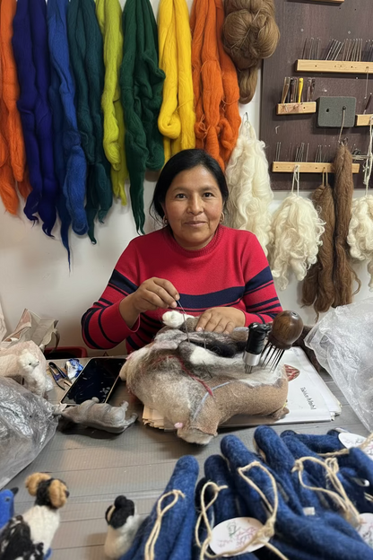 Woman working with animal felting at a table in a workshop setting.