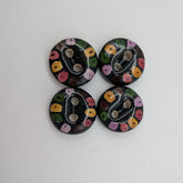 Four round buttons with floral patterns on a white background
