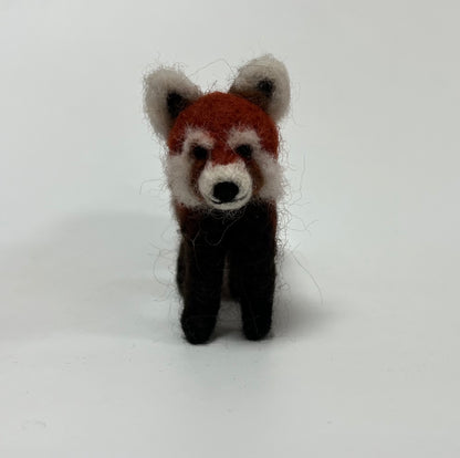 A handcrafted felted wool toy red panda standing upright against a plain white background.