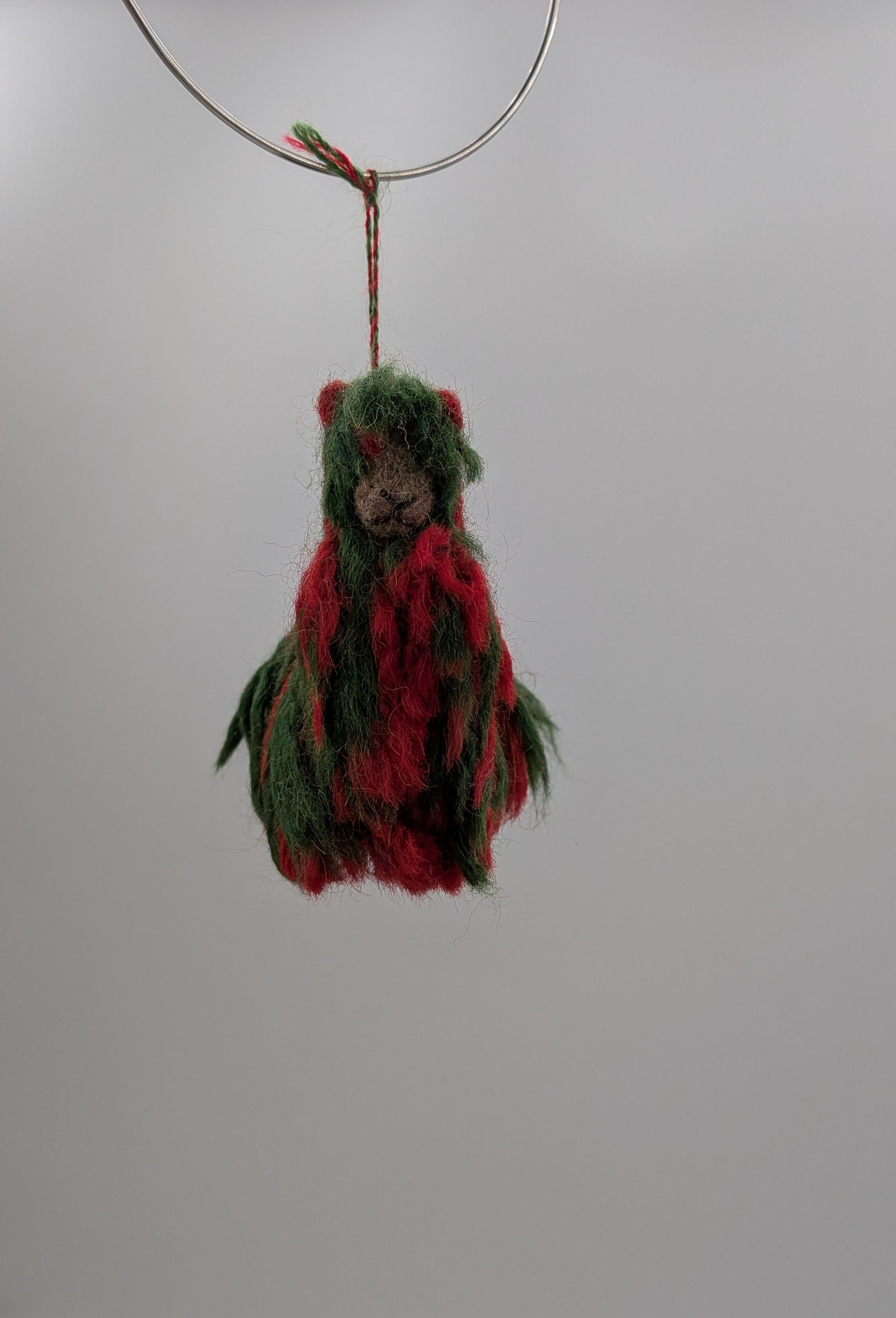 Decorative hanging figure with red and green details on a white background