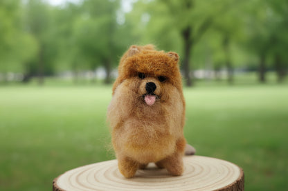 Cute felted dog ornament sculpture in a park on a wooden round