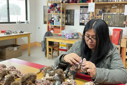 Person working on small hawksbill turtle items in an artist workshop setting