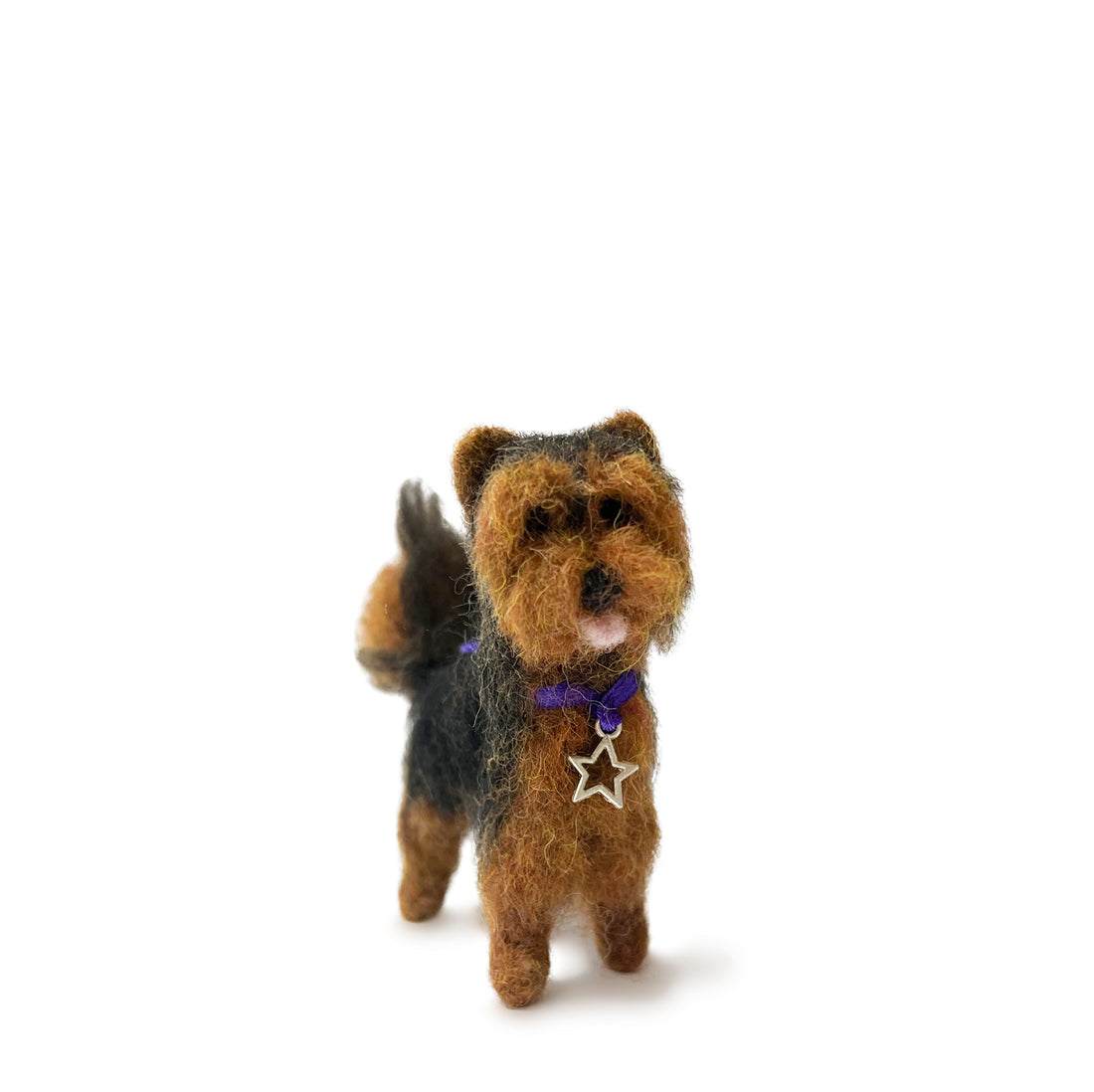 Stuffed felted dog with a star-shaped tag on a white background