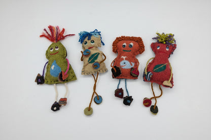 A group of handmade felt fabric creatures or dolls arranged on a plain white background. The figures are made from various colored felt materials with embroidered faces, yarn hair, and small dangling accessories.