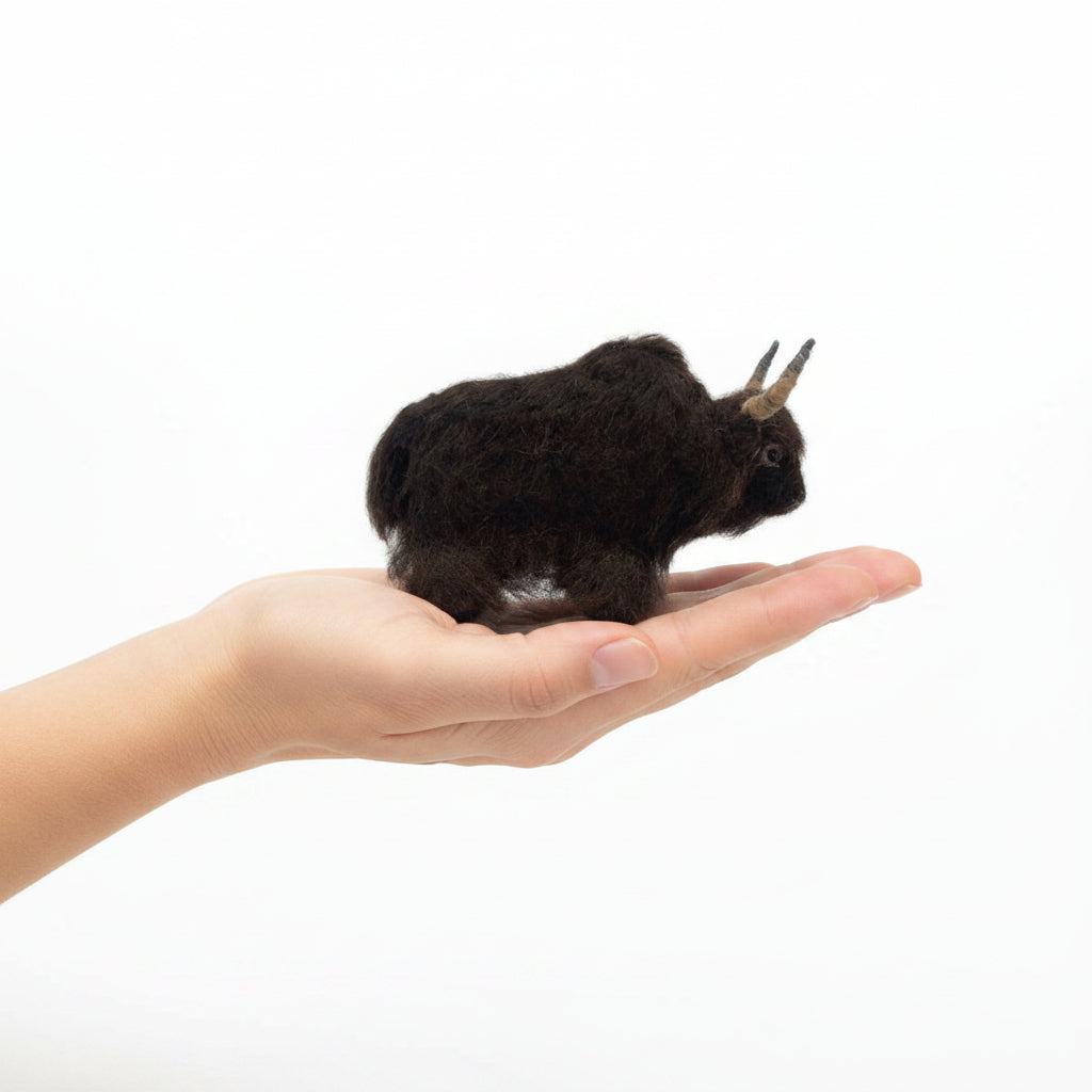 Plush yak of a dark brown alpaca fiber with horns on a white background