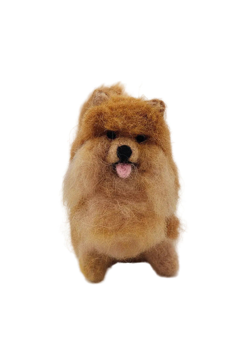 A fuzzy felted pomeranian dog resembling a fluffy brown dog on a wooden surface with a white background