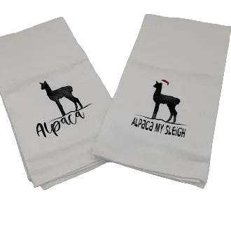 Two white towels with black alpaca designs and text on a light gray background