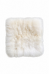 A square fluffy alpaca-fur pad in off-white/cream, laid flat.