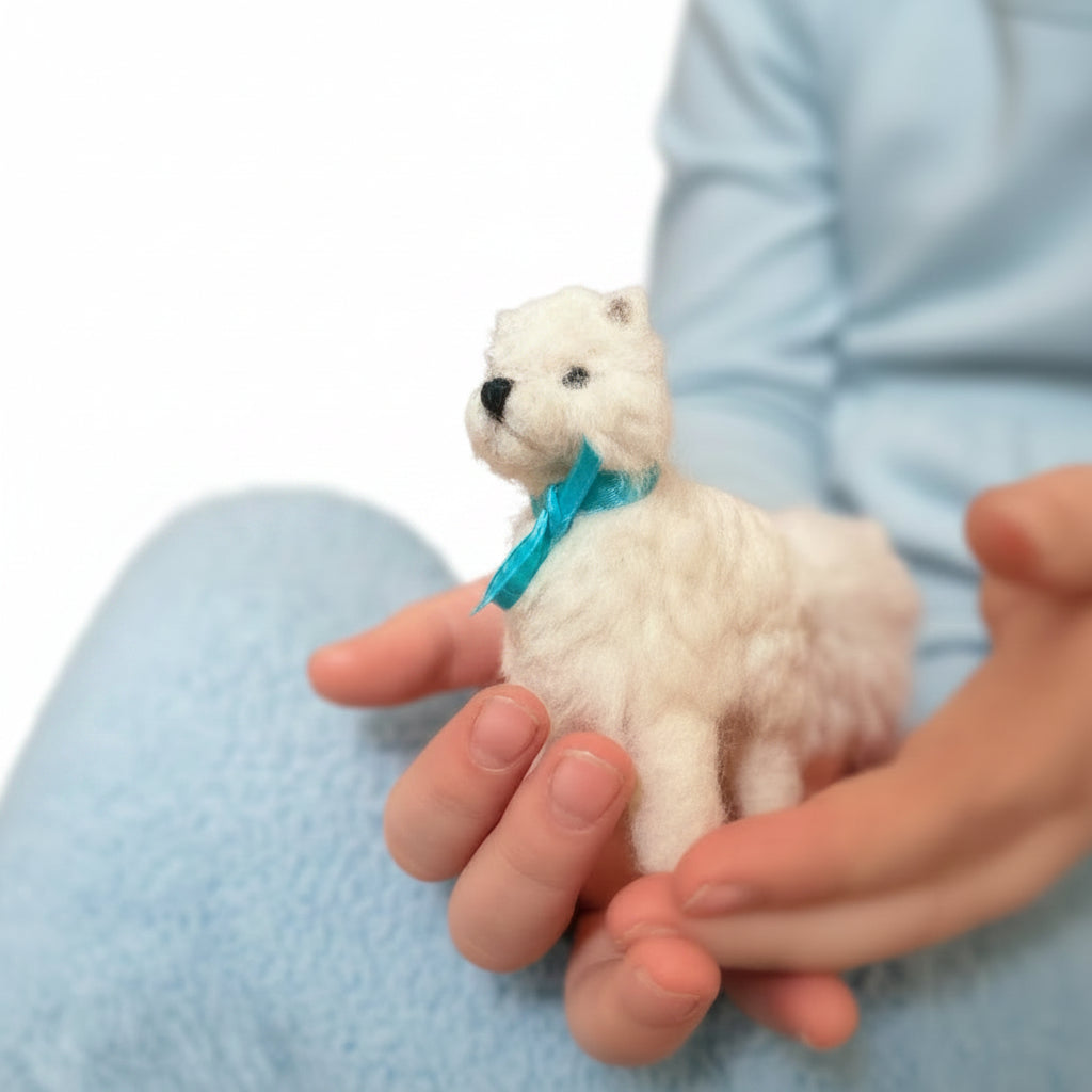 Small white dog with a blue ribbon held in hands against a blurred background