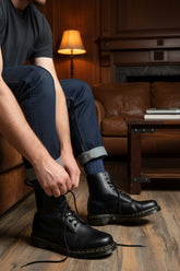 Person wearing blue socks on a wooden floor with storage boxes in the background