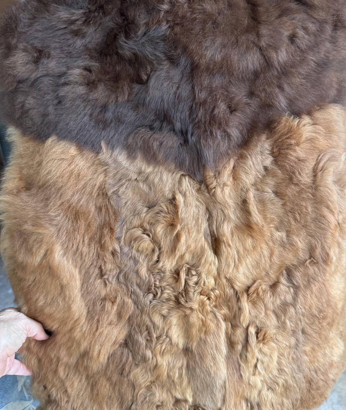 A large natural fur vest in two tones of brown and light brown.