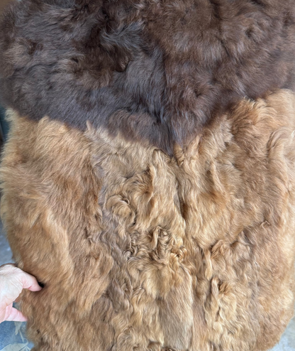 A large natural fur vest in two tones of brown and light brown.