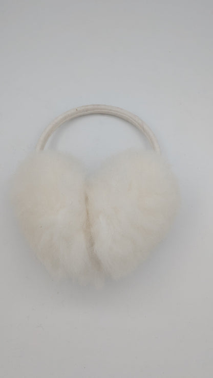 A pair of fluffy white faux-fur ear warmers attached to a thin beige elastic band, shown on a plain light gray background.