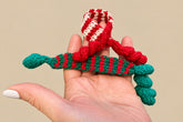 Tiny holiday scarves on a hand to show scale