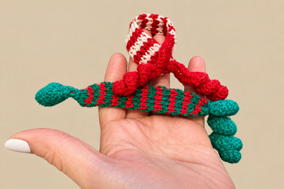 Tiny holiday scarves on a hand to show scale