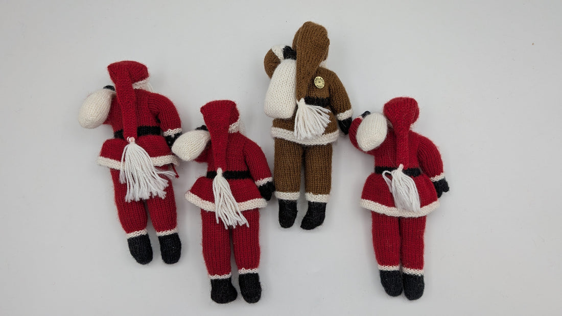 Four knitted Santa Claus and reindeer figures arranged vertically on a plain white background.