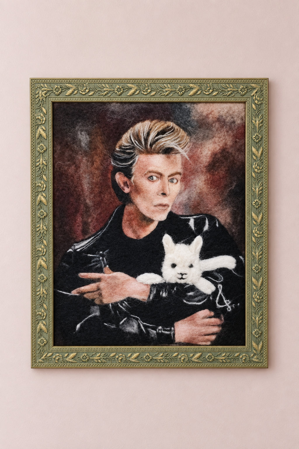 Framed needle-felted alpaca fiber portrait of a David Bowie and his alpaca hanging on a wall.