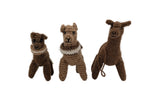 Three hand-crocheted alpaca dolls in various brown shades, each wearing a white lace collar, displayed on a white surface against a light gray background.