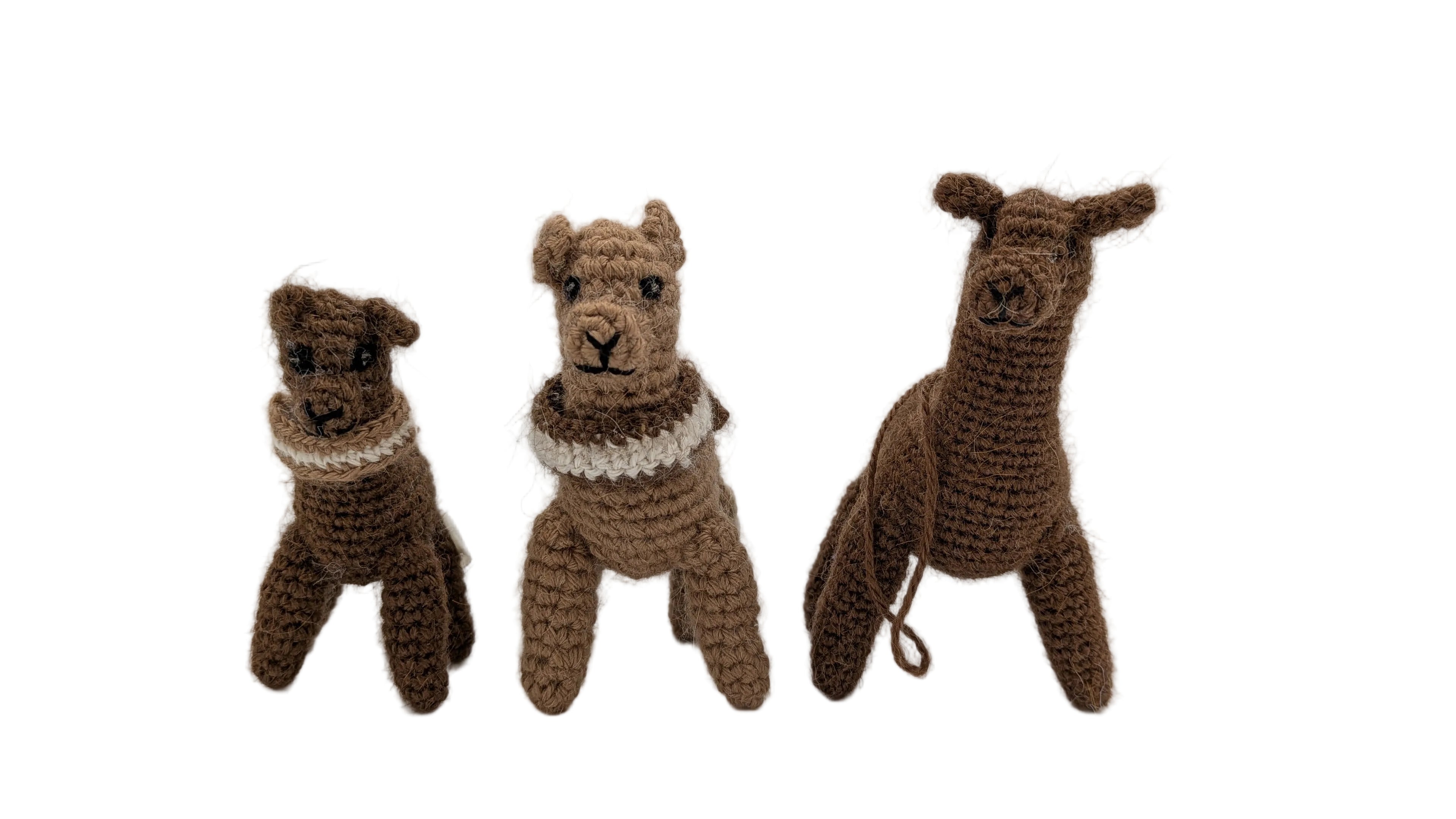 Three hand-crocheted alpaca dolls in various brown shades, each wearing a white lace collar, displayed on a white surface against a light gray background.