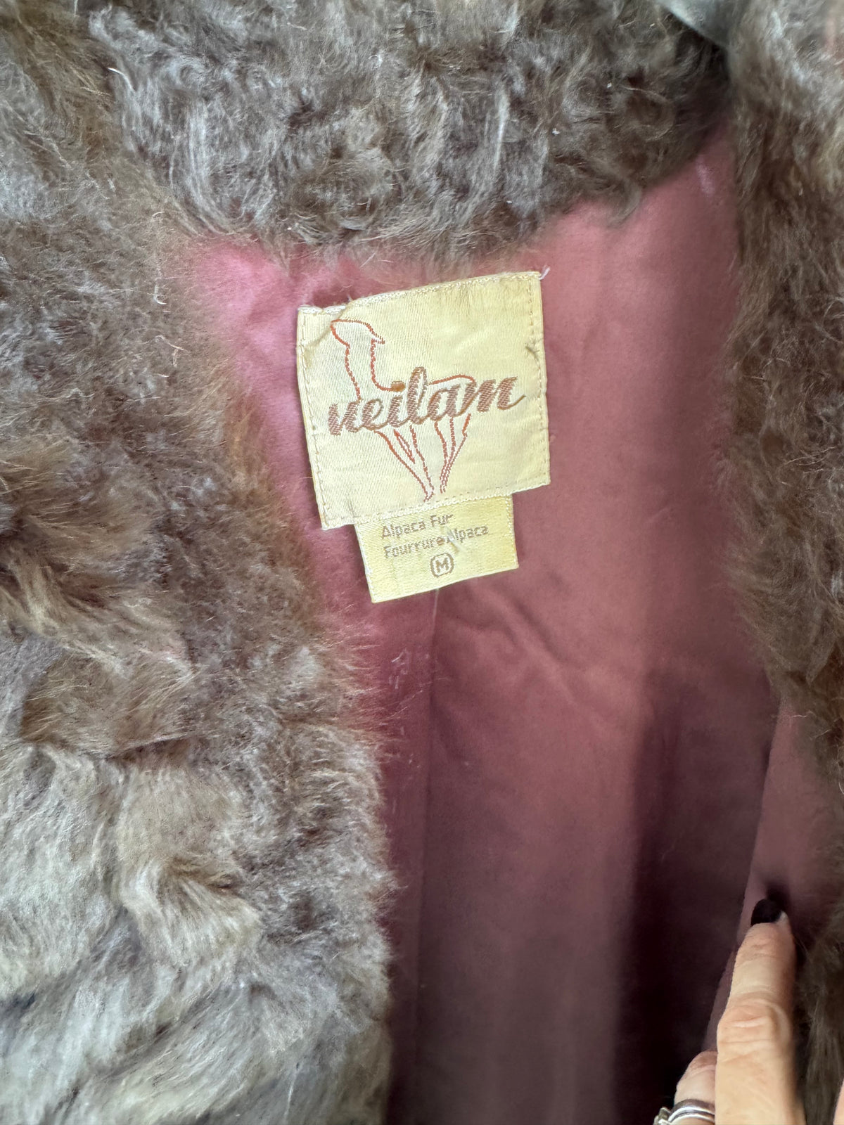 Close-up of a fur-trimmed garment showing a beige sewn-in label