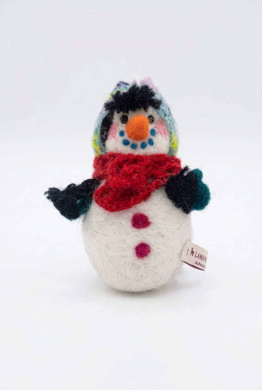 A needle-felted alpaca fiber snowman sculpture with a red hat, blue smile and carrot nose, against a white background.