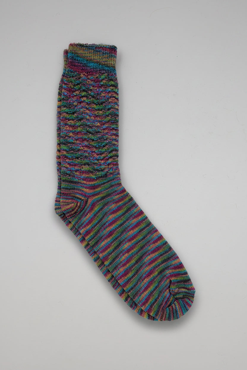 A single multicolor striped knit sock with horizontal bands of red, blue, green, yellow, and purple on a light gray background.