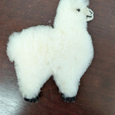 White plush toy shaped like a bear paw on a wooden surface