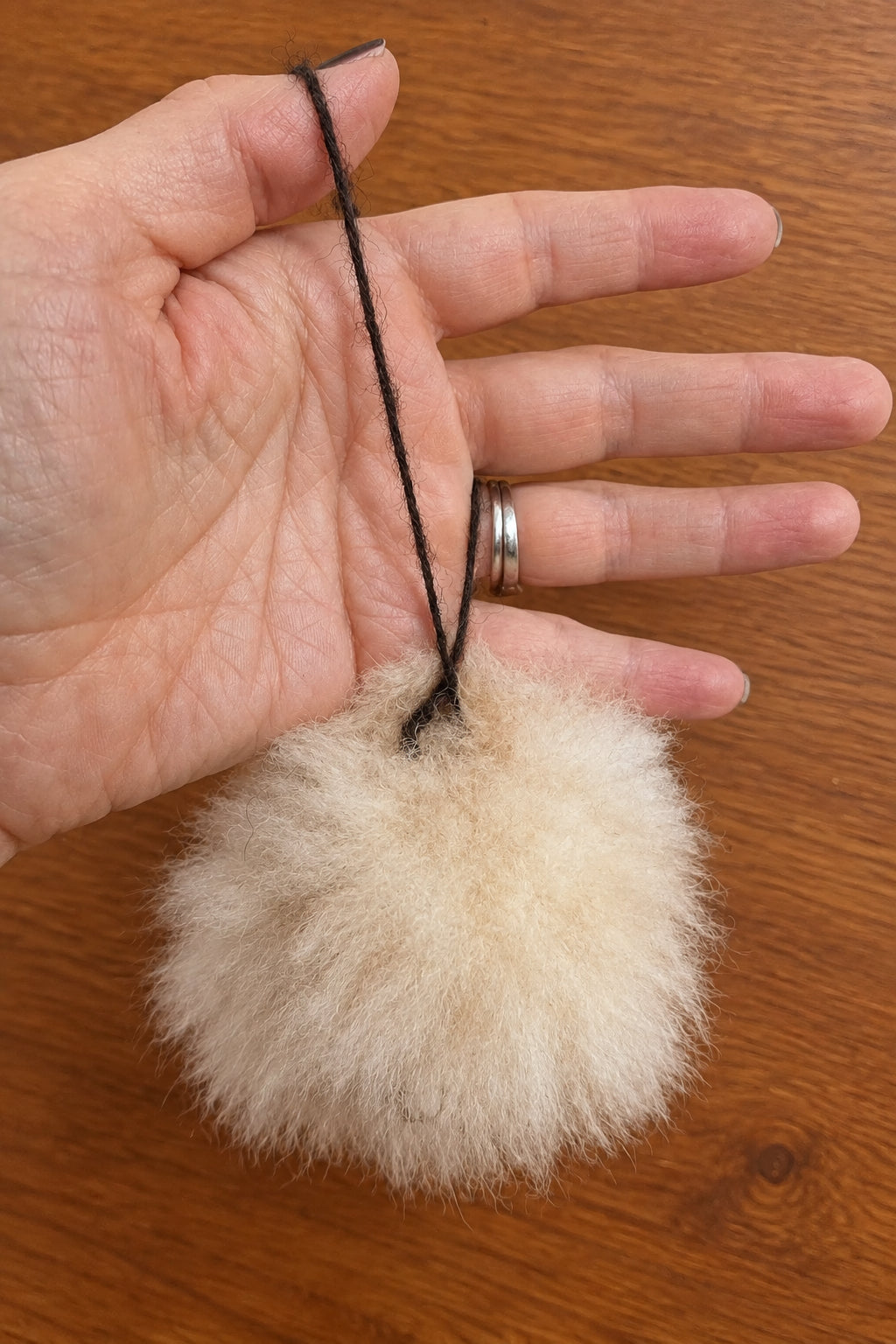 Felted alpaca fur pompom featuring a handcrafted face with 