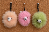 Plush fur pompom featuring a handcrafted faces in three colors