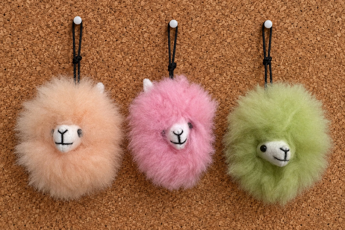 Plush fur pompom featuring a handcrafted faces in three colors